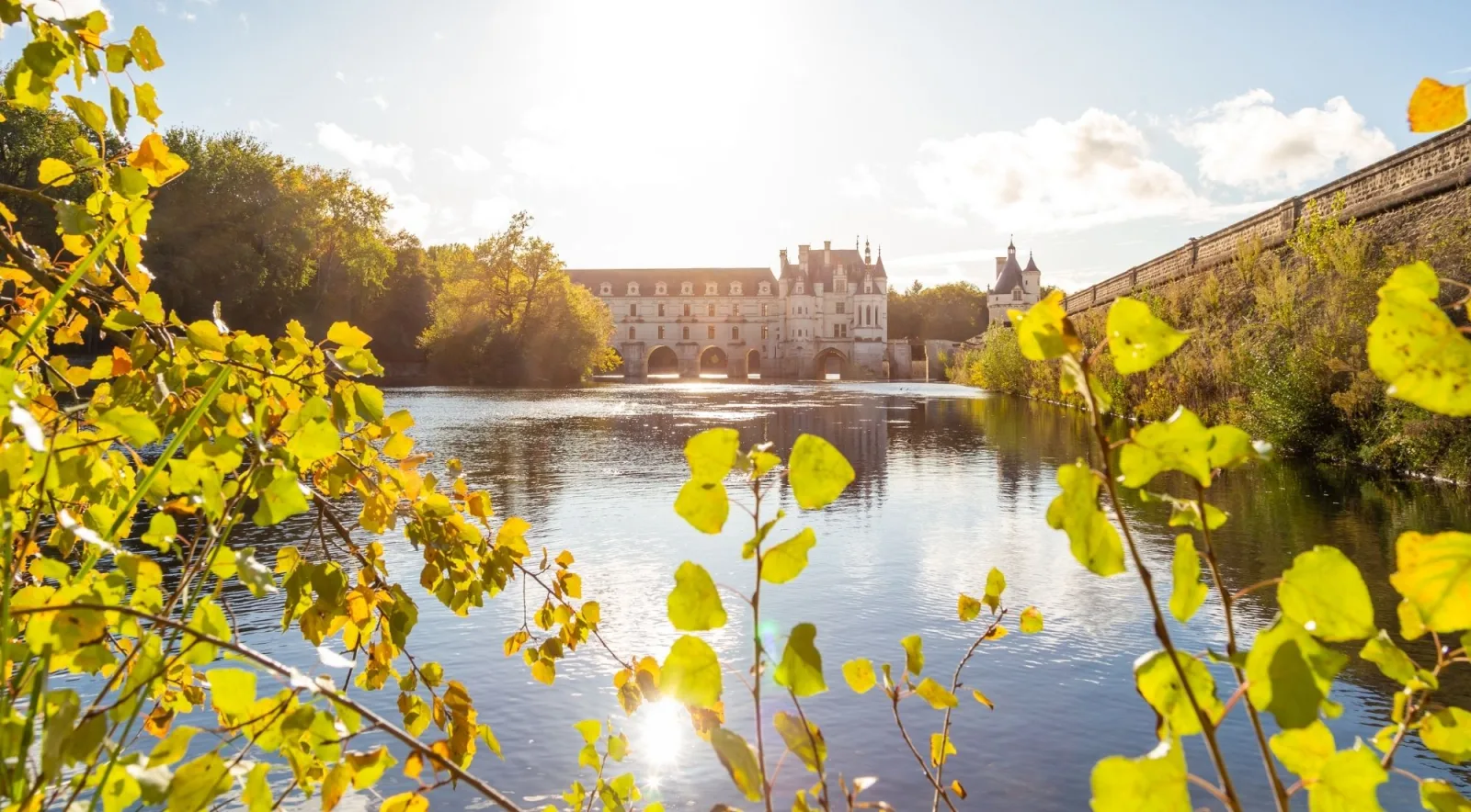 Château de Chenonceau seen across the River Cher through backlit autumn leaves