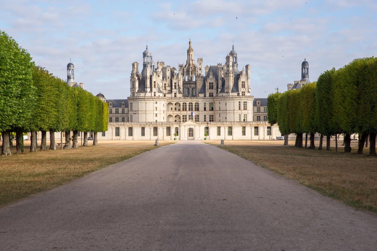 Chambord's façade at the end of the tree-lined gravel avenue