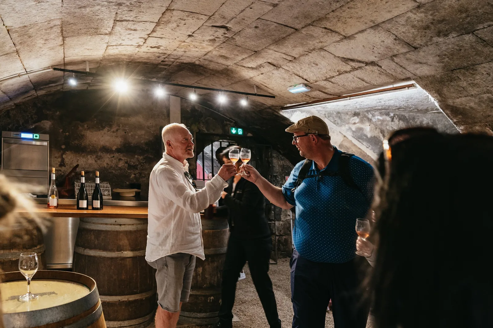 Guests toasting Loire wines in Chenonceau's vaulted stone wine cellar