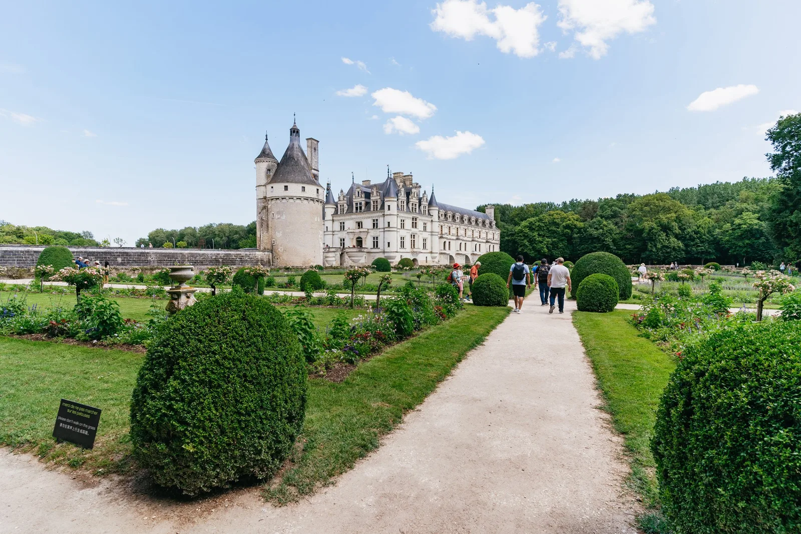 A gravel path through Chenonceau's clipped garden parterres towards the château