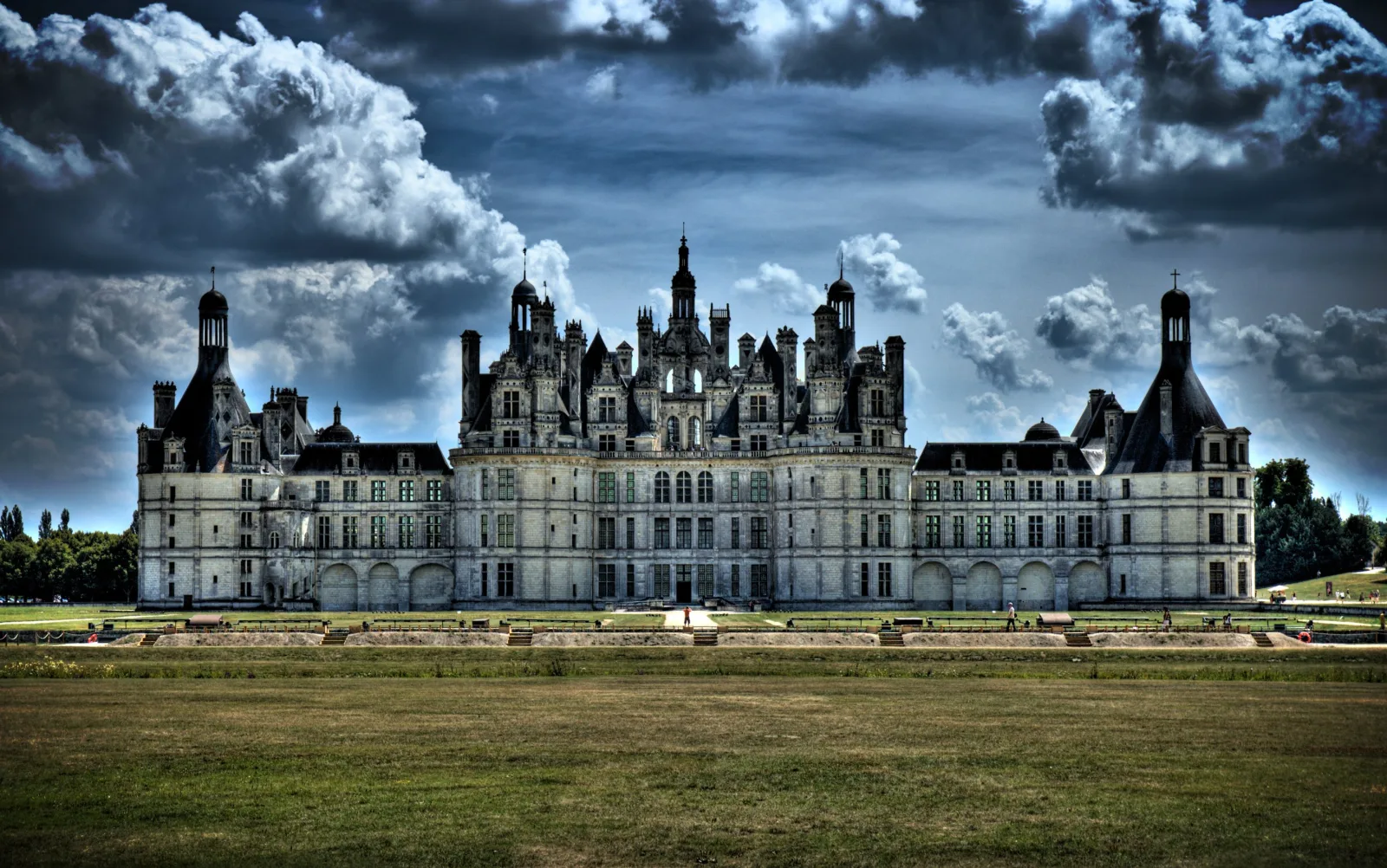 Château de Chambord's full façade under a dramatic cloudy sky