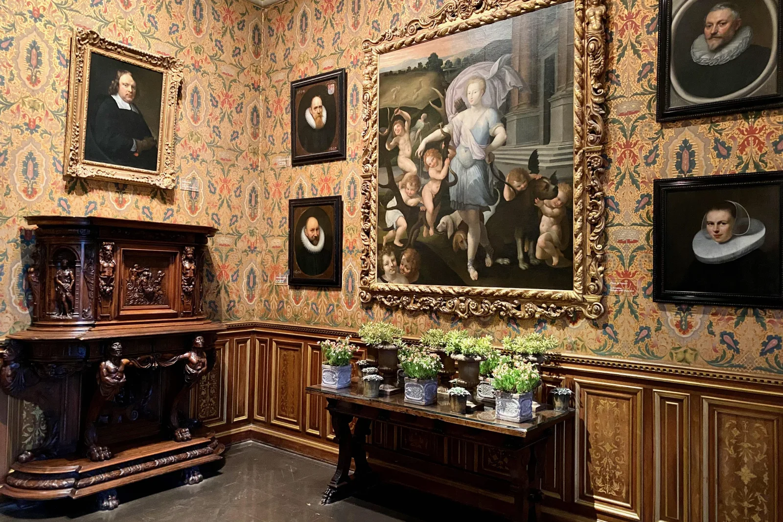 A panelled château room hung with 17th-century paintings