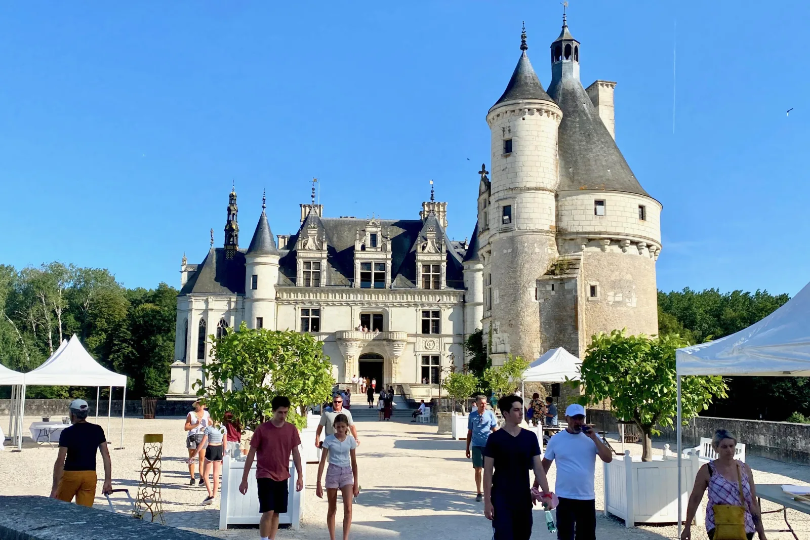 Visitors on the forecourt of Château de Chenonceau on a clear day