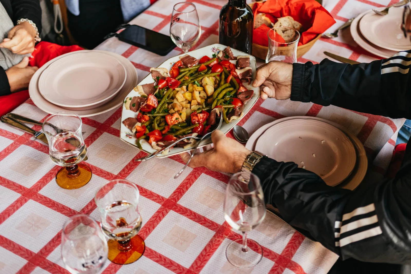 A checked-cloth table set with Loire wines and a shared lunch dish