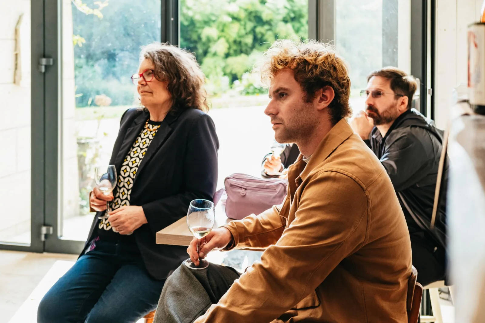 Guests tasting Loire wines in an estate tasting room overlooking the vines